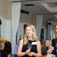 Group of 4 chatting together while one enjoys the food at the event